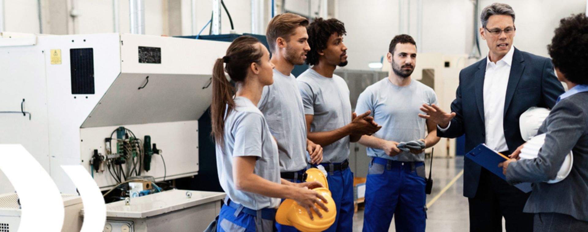 Mitarbeiter in der Produktion im Gespräch, symbolisieren den Workshop zur Wertstromanalyse und -design.